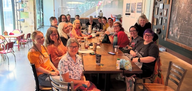 A group gathered around a long table with 1888 coffee